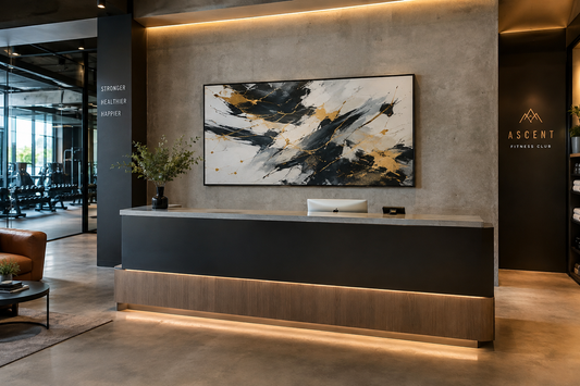 Boutique luxury fitness club reception lounge with matte black framed dynamic abstract canvas wall art